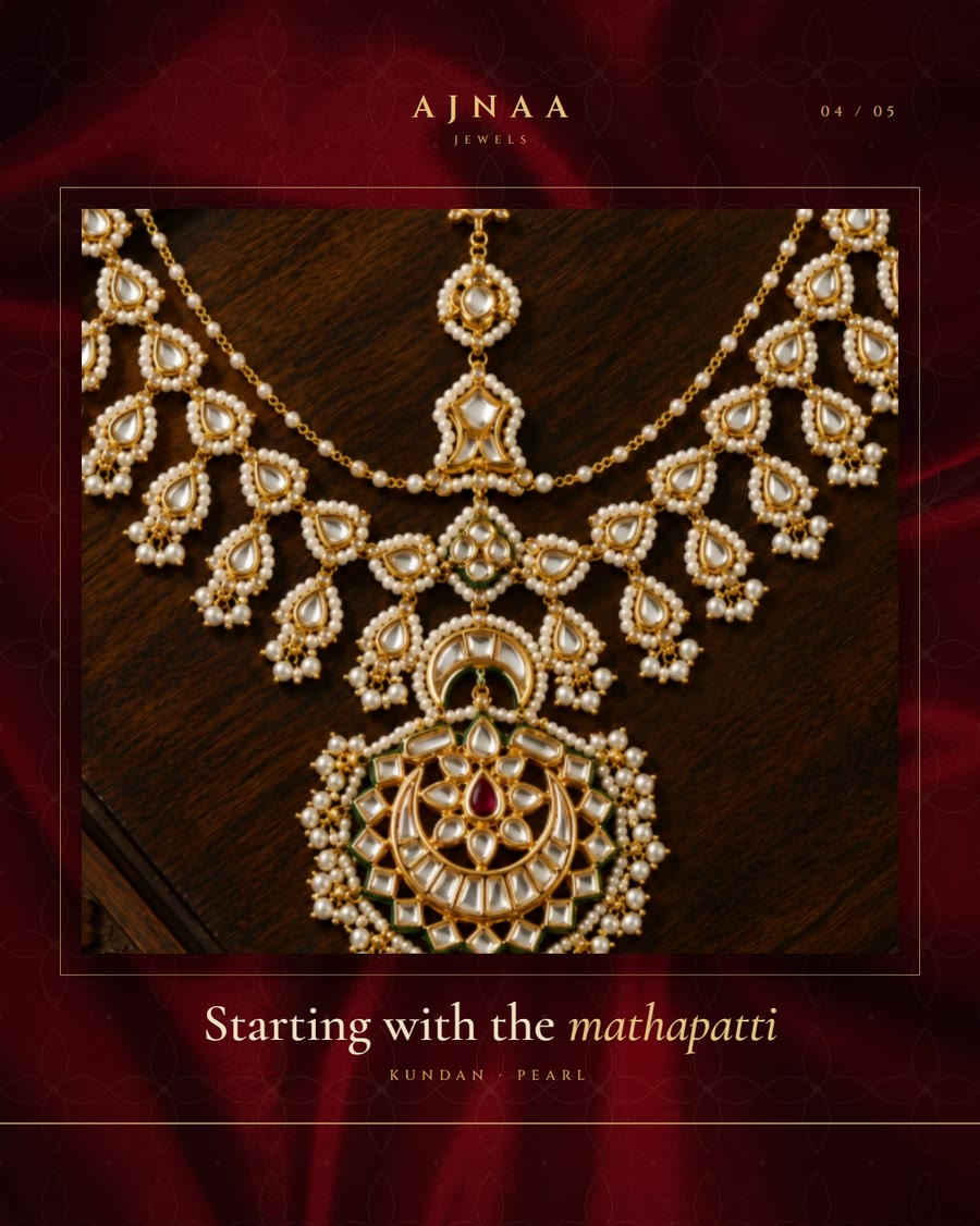 Carousel slide four: a kundan and pearl necklace set on dark wood, Starting with the mathapatti.